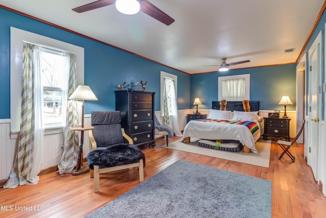 bedroom featuring ceiling fan, ornamental molding, and wood-type flooring