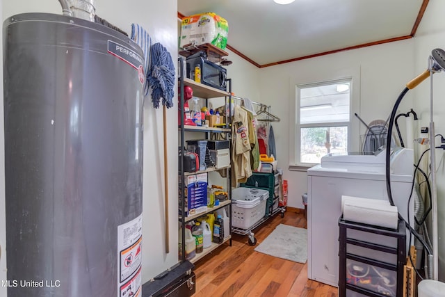 washroom with washing machine and clothes dryer, ornamental molding, light hardwood / wood-style floors, and water heater