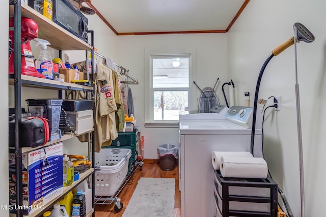 clothes washing area featuring crown molding, independent washer and dryer, and wood-type flooring