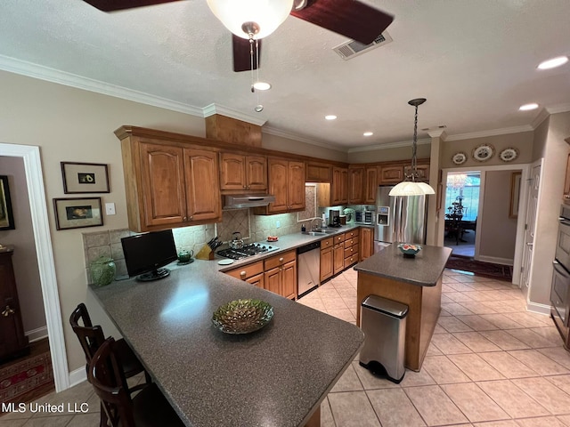 kitchen featuring hanging light fixtures, crown molding, light tile patterned floors, appliances with stainless steel finishes, and ceiling fan