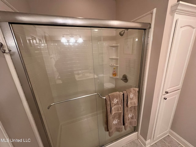 bathroom featuring walk in shower and tile patterned flooring