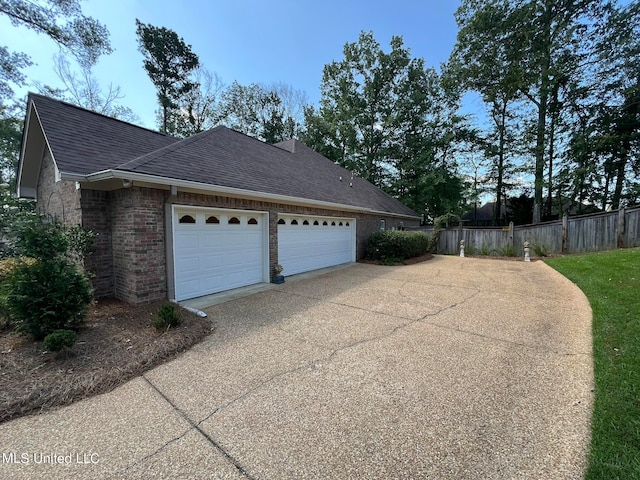 view of side of home featuring a garage and a lawn