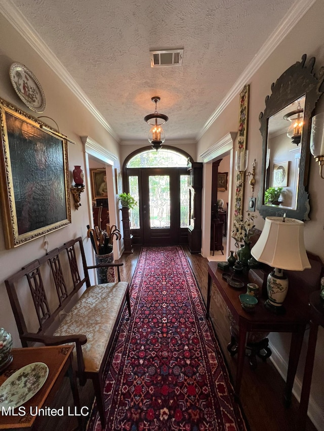 interior space with ornamental molding, a textured ceiling, and hardwood / wood-style flooring