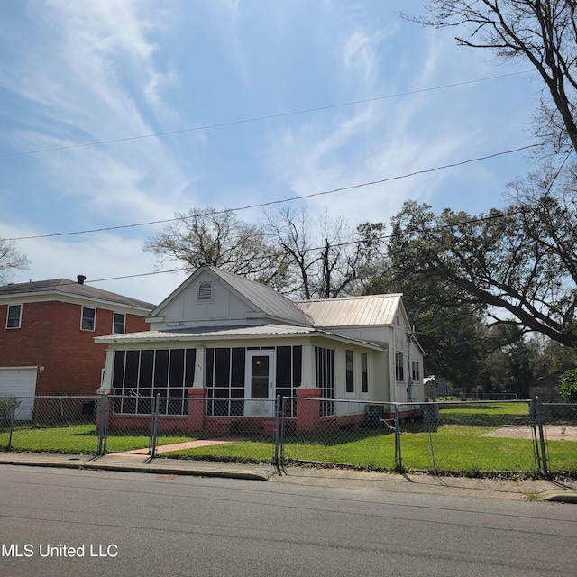 farmhouse with a fenced front yard, a sunroom, and a front yard