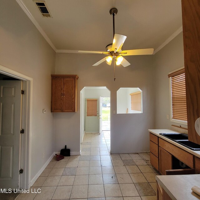 kitchen featuring brown cabinetry, ornamental molding, and ceiling fan