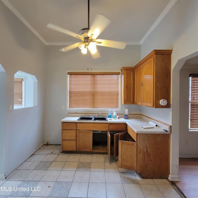 kitchen with light countertops, brown cabinets, ceiling fan, and crown molding