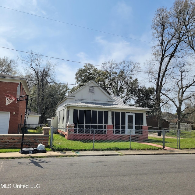 view of front of home featuring a sunroom, a front lawn, and fence private yard