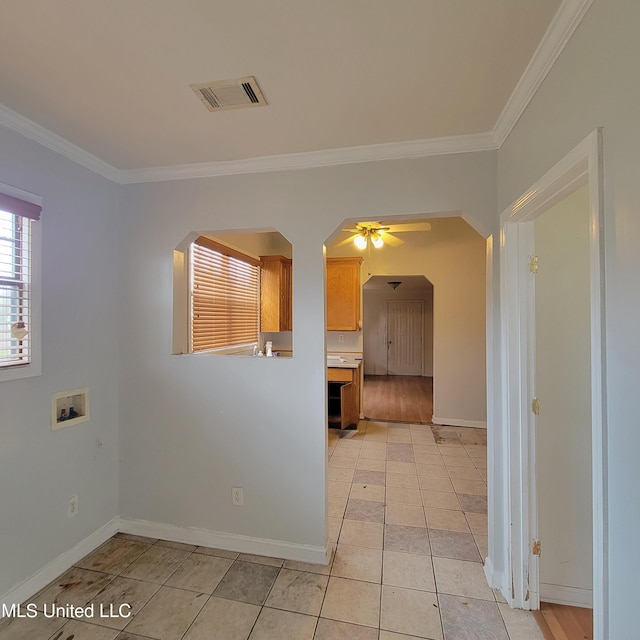 interior space featuring arched walkways, ornamental molding, visible vents, and baseboards