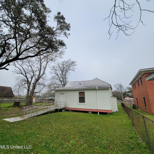 back of house featuring a yard, fence, and board and batten siding