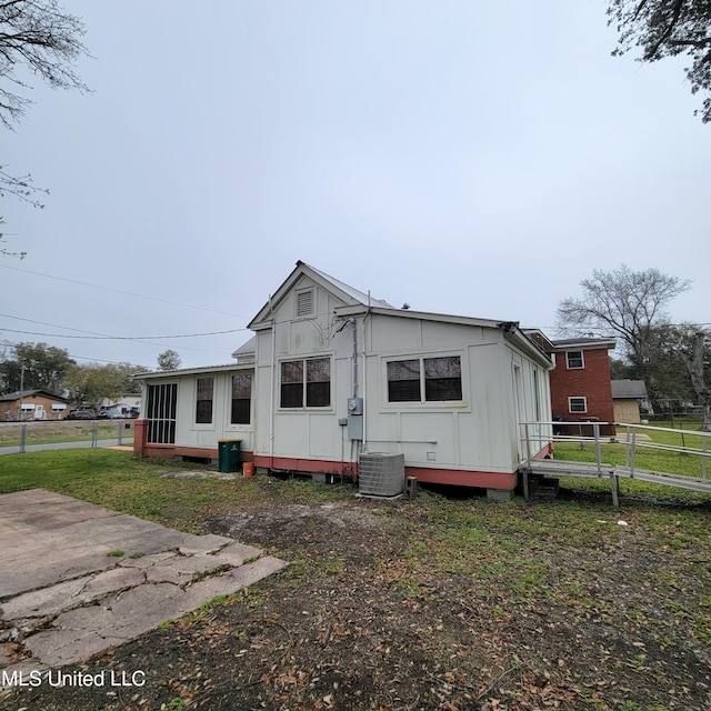 back of house featuring central air condition unit and fence