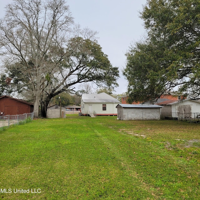 view of yard with an outdoor structure, fence, and a shed