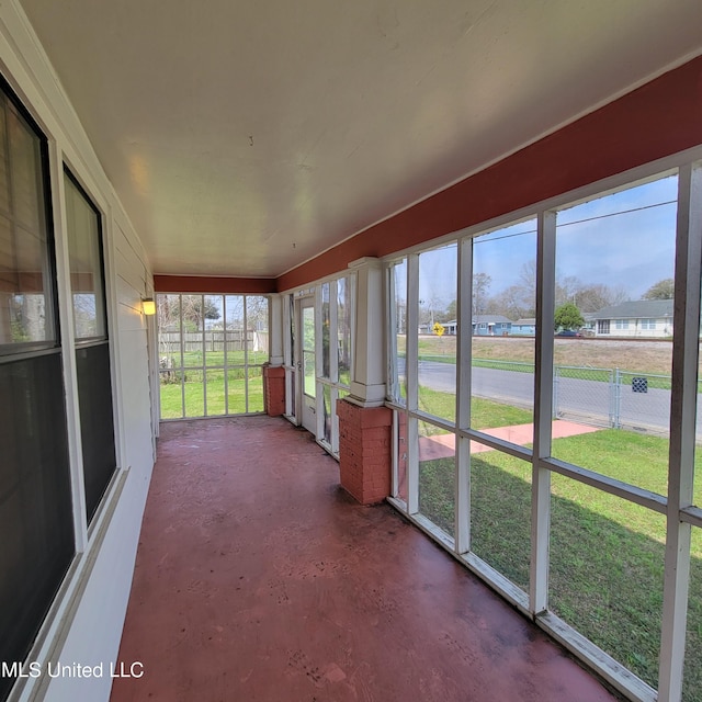 unfurnished sunroom featuring concrete floors