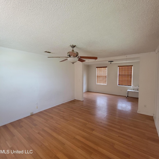 empty room with light wood finished floors, a textured ceiling, visible vents, and ceiling fan