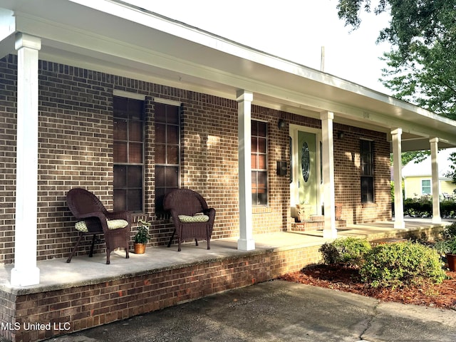 view of exterior entry featuring covered porch