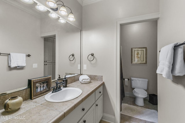 bathroom featuring vanity, ornamental molding, toilet, and tile patterned flooring