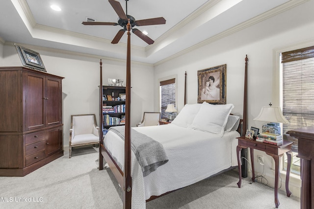 bedroom featuring light colored carpet, a tray ceiling, and ceiling fan