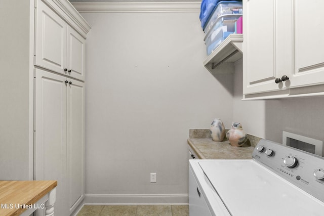 laundry area featuring washer / dryer, light tile patterned floors, and cabinets