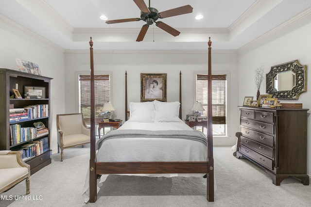 carpeted bedroom featuring crown molding, a raised ceiling, and ceiling fan