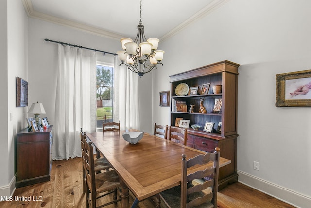 dining room with crown molding, hardwood / wood-style floors, and a chandelier