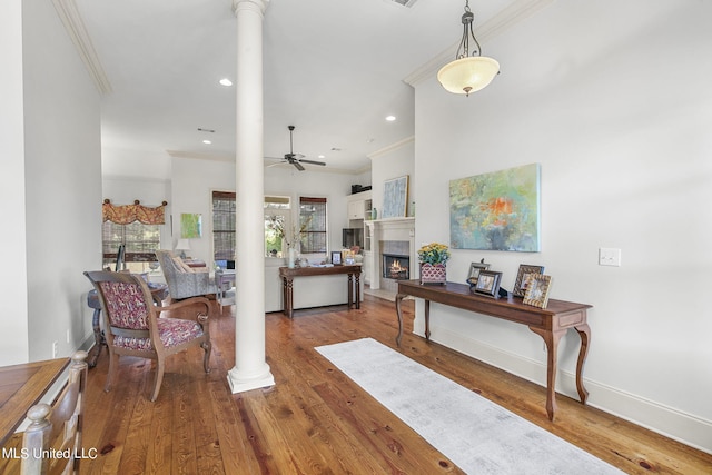 entrance foyer featuring hardwood / wood-style floors, crown molding, and decorative columns