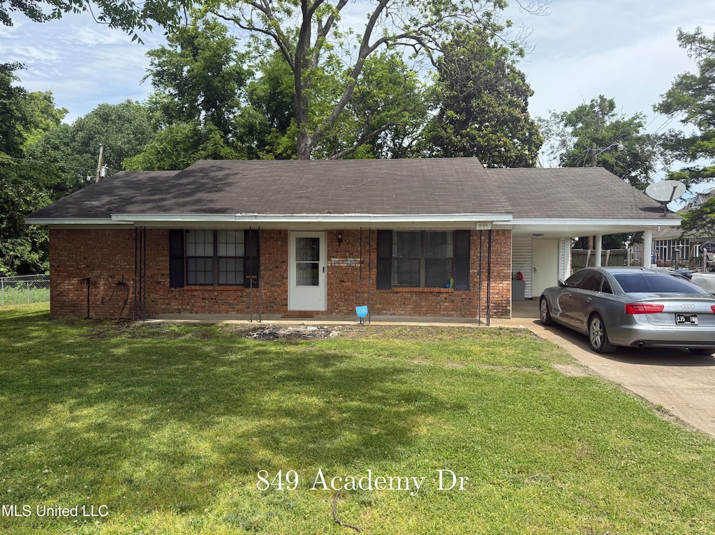 single story home featuring concrete driveway, a front yard, brick siding, an attached carport, and roof with shingles