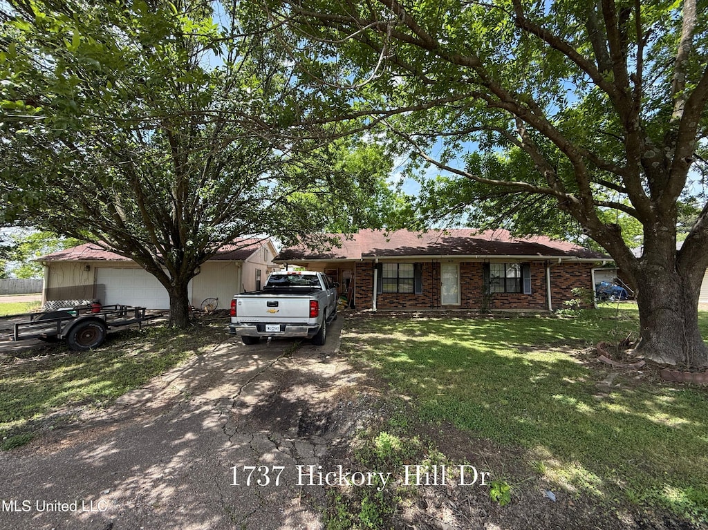 ranch-style home featuring a front lawn, driveway, and brick siding
