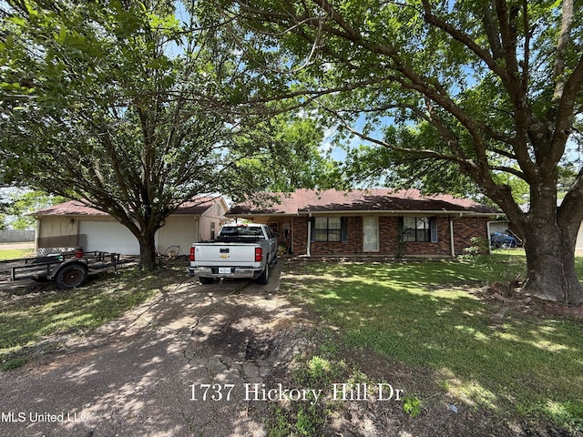 ranch-style home featuring a front lawn, driveway, and brick siding