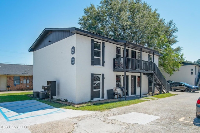 view of property featuring stairway and central AC unit