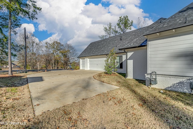 view of property exterior featuring a lawn and a garage