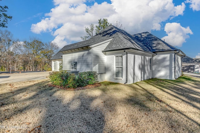 view of side of home with a yard