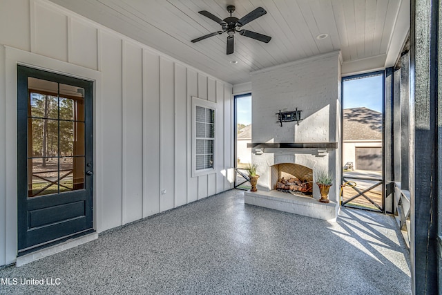 unfurnished sunroom with ceiling fan, plenty of natural light, and wood ceiling