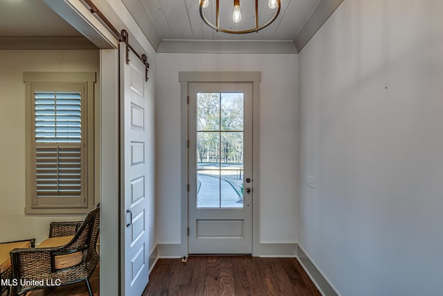 doorway to outside featuring dark hardwood / wood-style flooring, ornamental molding, a barn door, and an inviting chandelier