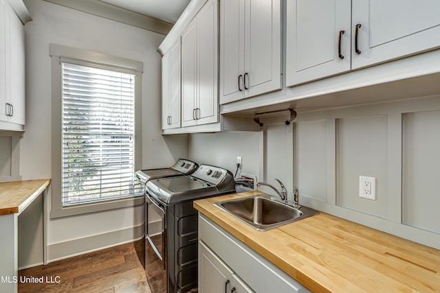 washroom with cabinets, washer and dryer, a healthy amount of sunlight, and sink