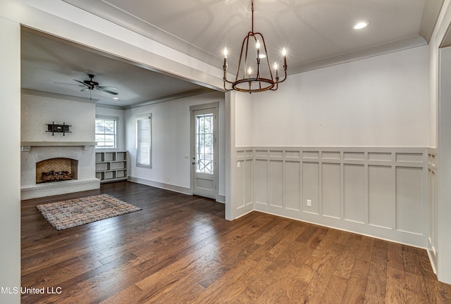 foyer entrance with a wealth of natural light, crown molding, ceiling fan with notable chandelier, and dark hardwood / wood-style floors