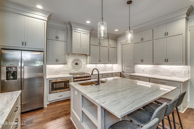 kitchen featuring stainless steel refrigerator with ice dispenser, built in microwave, light stone counters, and an island with sink