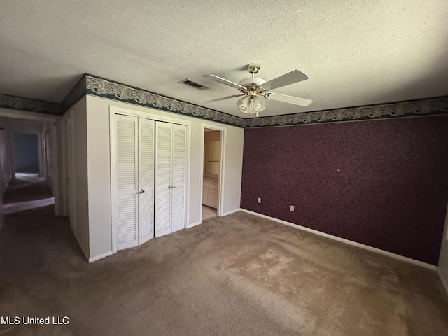 unfurnished bedroom with a closet, carpet flooring, baseboards, a ceiling fan, and a textured ceiling