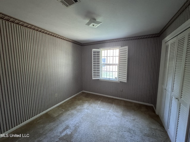 unfurnished bedroom featuring a closet, carpet flooring, and baseboards