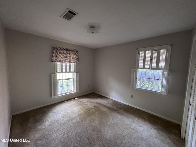 carpeted empty room featuring plenty of natural light and baseboards