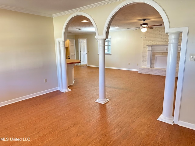 unfurnished living room featuring a fireplace, a textured ceiling, ceiling fan, ornamental molding, and light hardwood / wood-style flooring