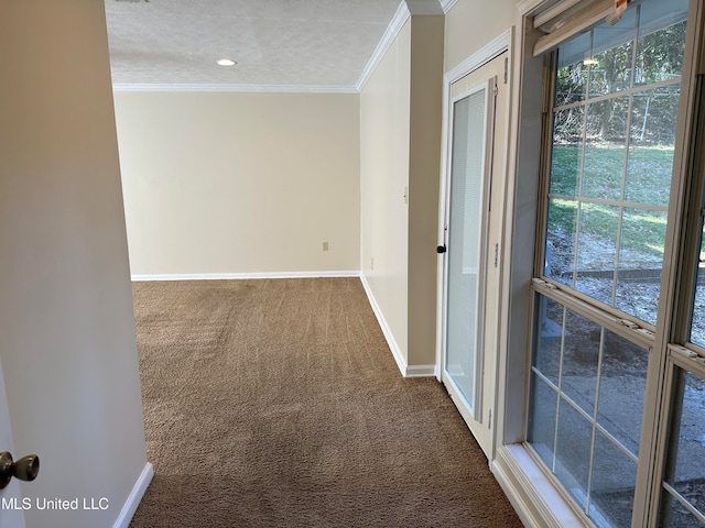 hall with ornamental molding, a textured ceiling, and carpet