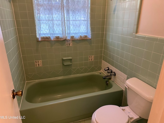 bathroom with toilet and tile walls