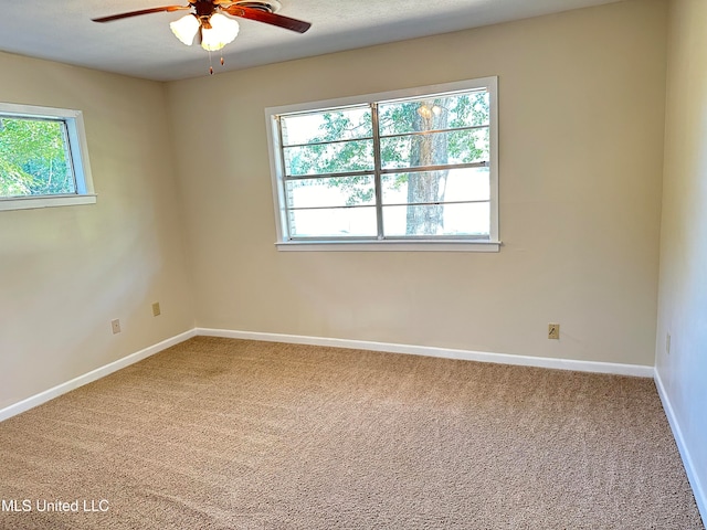 empty room with carpet, plenty of natural light, and ceiling fan