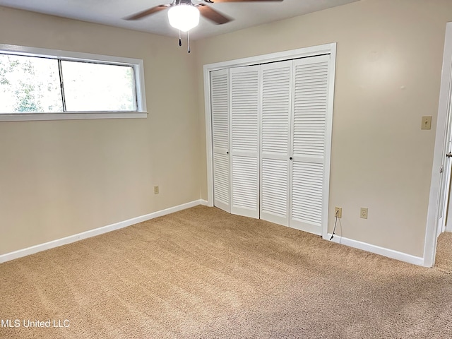 unfurnished bedroom featuring a closet, carpet flooring, and ceiling fan