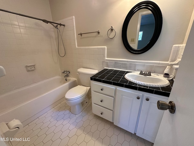 full bathroom featuring toilet, tile patterned floors, tiled shower / bath, vanity, and decorative backsplash