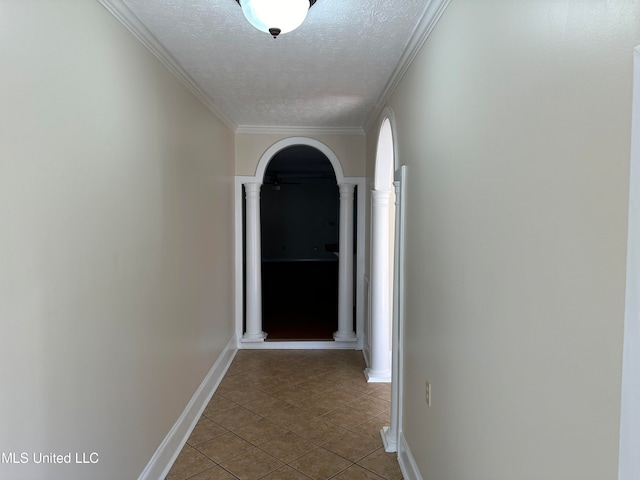 corridor with crown molding, decorative columns, a textured ceiling, and tile patterned flooring