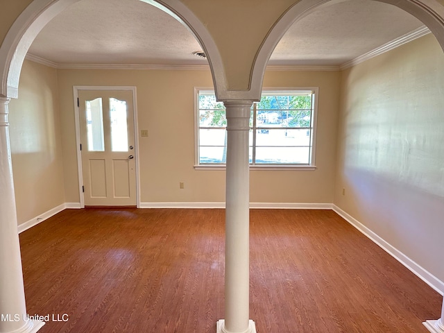 foyer entrance with ornamental molding, hardwood / wood-style floors, and a textured ceiling