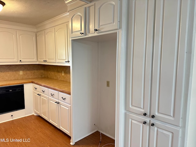 kitchen featuring light hardwood / wood-style floors, white cabinets, tasteful backsplash, and dishwasher