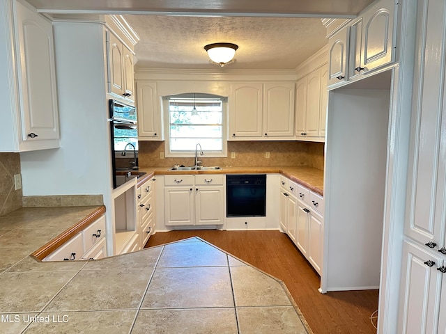 kitchen featuring white cabinets, hardwood / wood-style flooring, black appliances, tile counters, and sink