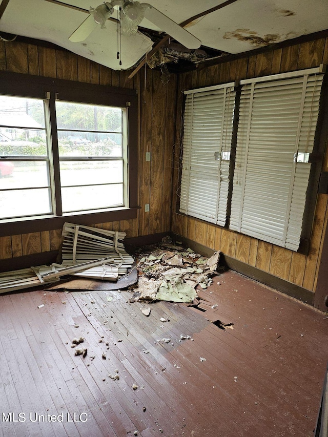 miscellaneous room with lofted ceiling, wooden walls, hardwood / wood-style flooring, and ceiling fan