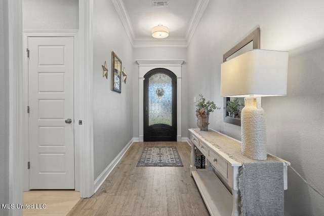 entryway with ornamental molding and light hardwood / wood-style flooring